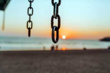 chain free house meaning banner showing hanging chains on a beach