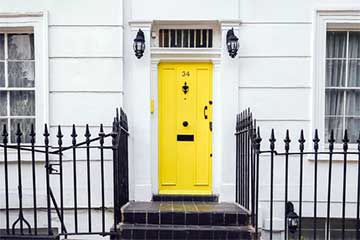 costs of buying a house banner showing a yellow front door